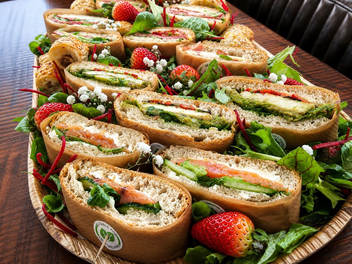 Sandwich platter surrounded by pork rolls and rocket